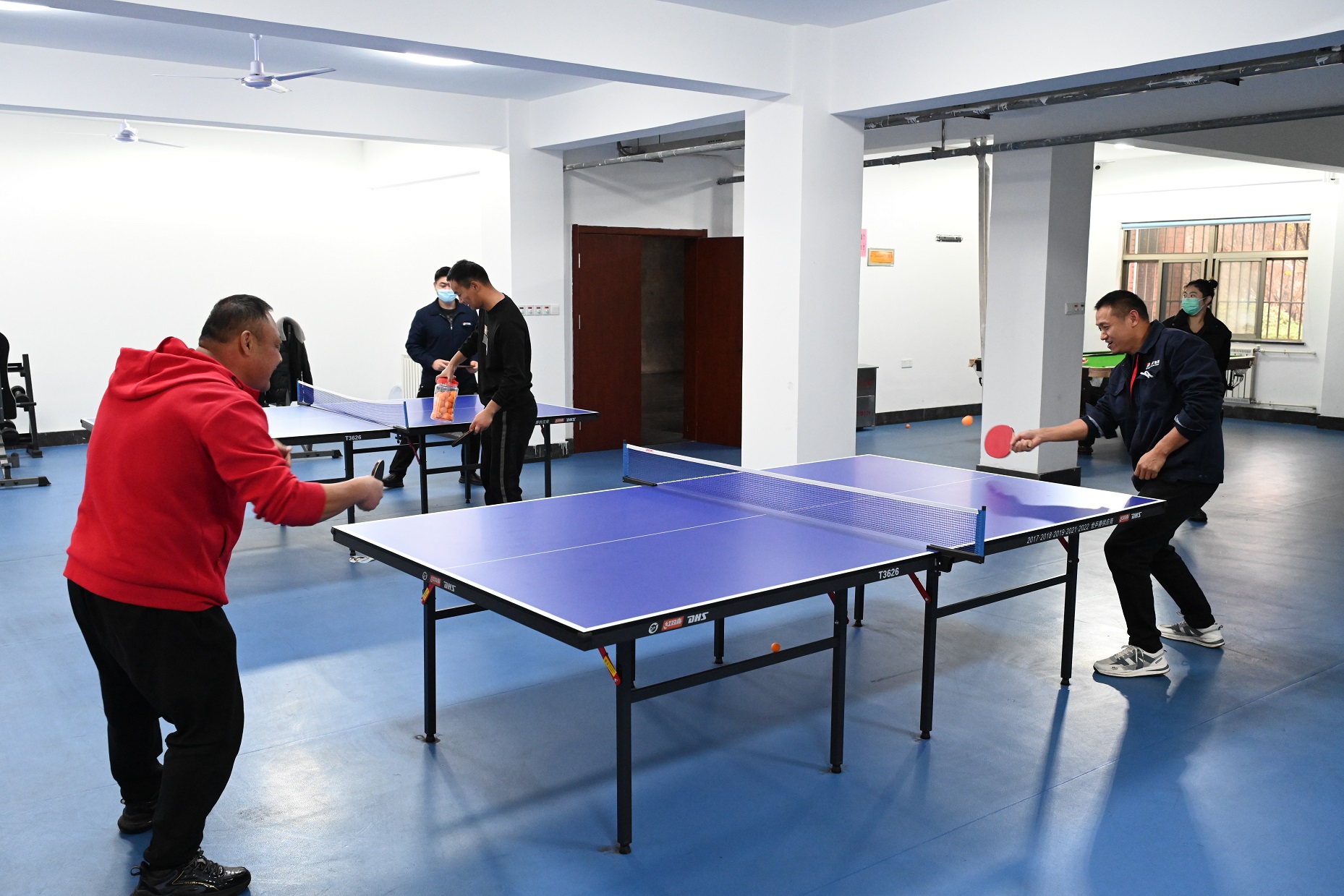 1689580877236634.jpg 图为:职工在健身活动室里进行乒乓球比赛.jpg